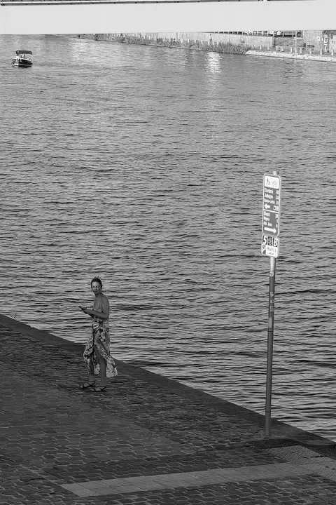 Passante seule sur le quai au crépuscule, bateau de promenade sur l'eau, Namur