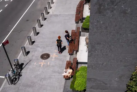 Vue plongeante sur un trottoir bordé de banquettes et de plantes vertes, New York