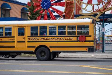 Bus scolaire jaune garé devant l'entrée colorée de Coney Island, New York