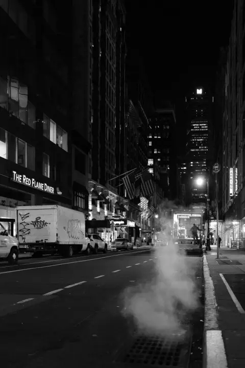 Silhouette marchant dans une rue nocturne bordée de drapeaux américains, New York
