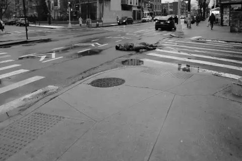 Silhouette étendue au milieu d'un passage piéton mouillé, New York