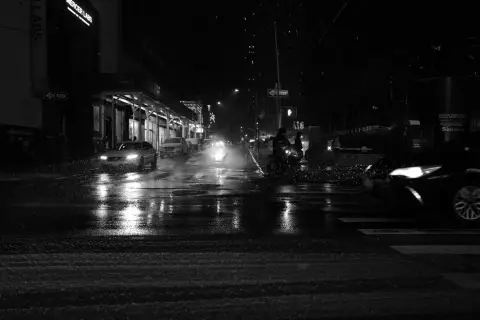 Voitures et cyclistes dans une rue enneigée la nuit, New York