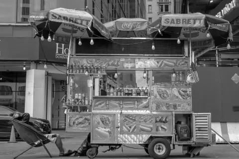 Vendeur de hot-dogs se reposant près de son chariot Sabrett, New York