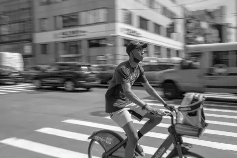 Cycliste flou en casquette traversant un carrefour à vive allure, New York