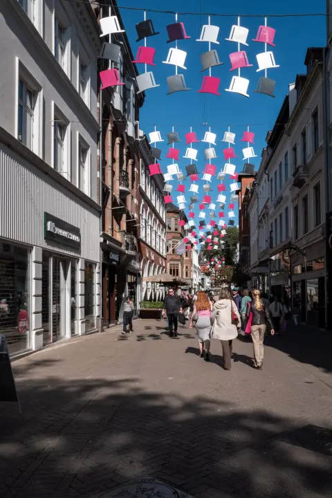 Les passants remontent la rue sous les chapeaux suspendus, Odense