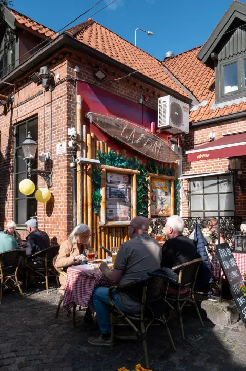Des clients en terrasse devant un restaurant de briques, Odense