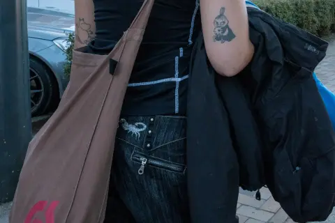 Un tatouage de la Petite My sur un bras, un sac de toile à l’épaule, Odense