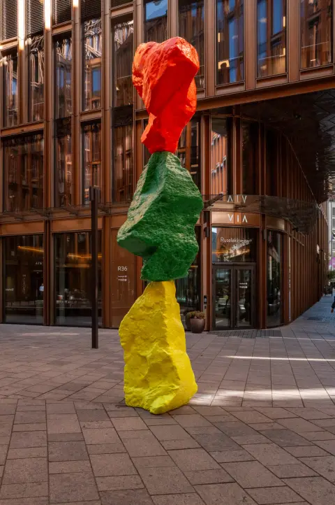 Une sculpture de blocs rouge, vert et jaune empilés devant un immeuble, Oslo