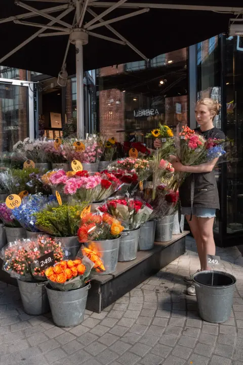 Une fleuriste devant ses seaux de fleurs colorées, Oslo