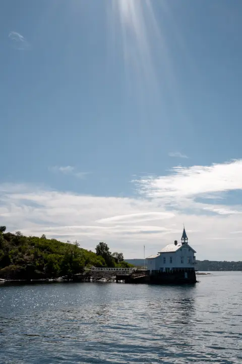 Le phare de Dyna sur son îlot, sous un rayon de soleil, Oslo