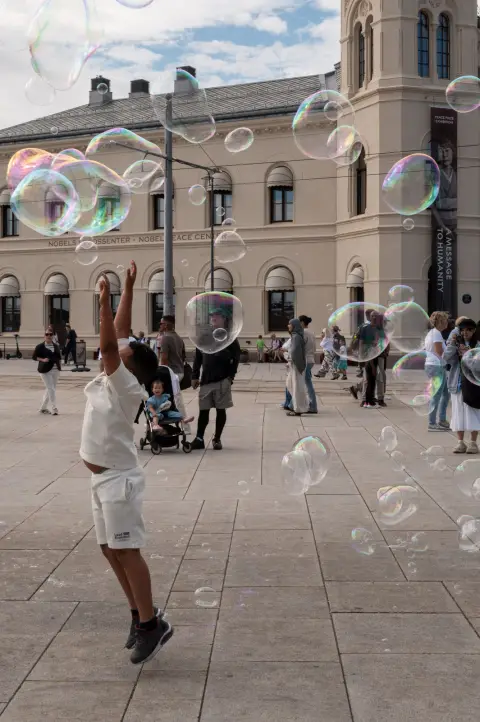 Un enfant saute pour attraper des bulles de savon, Oslo