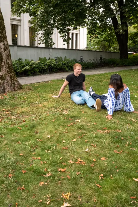 Un couple assis dans l’herbe sous les arbres, Oslo