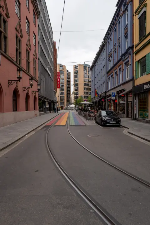 Une rue aux rails de tram, un passage piéton arc-en-ciel au loin, Oslo