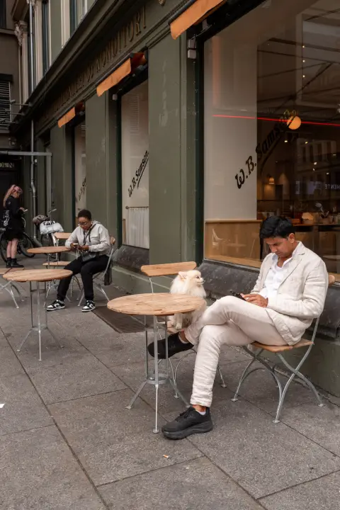 Un homme en costume blanc à une terrasse de café, Oslo