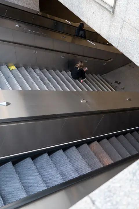 Escalators seen from above, a lone passenger, Paris