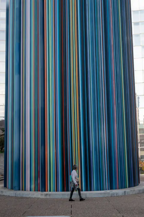 A tiny passer-by at the foot of the striped chimney, Paris