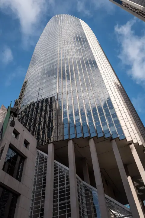 Gratte-ciel de verre incurvé reflétant les nuages, vue plongeante depuis le trottoir, San Francisco