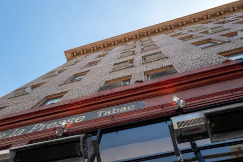 Contre-plongée sur la façade en briques du bar à tabac La Presse, San Francisco