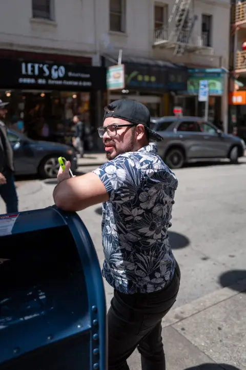 Homme en chemise fleurie prenant un selfie près d'une boîte aux lettres bleue, San Francisco