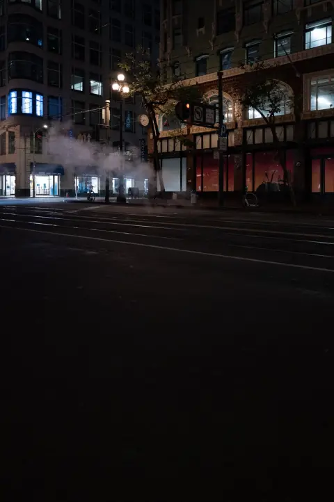 Vapeur nocturne s'échappant du sol près des vitrines éclairées du magasin Ross, San Francisco