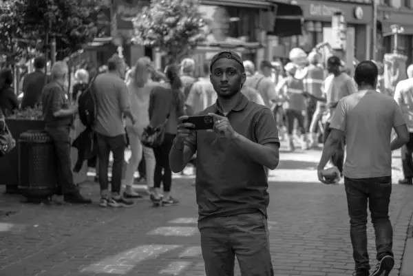 Un jeune homme filme au téléphone au milieu de la rue, Zinneke Parade, Bruxelles (planche 038)