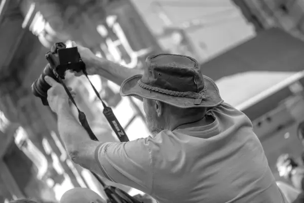 Photographe au chapeau de cuir qui lève son appareil au-dessus de la tête, Zinneke Parade, Bruxelles (planche 063)