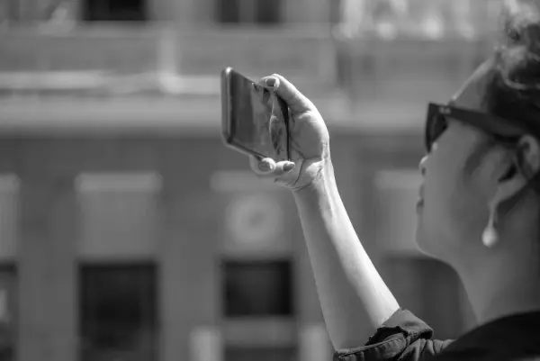 Une femme aux lunettes noires lève son téléphone, Zinneke Parade, Bruxelles (planche 082)