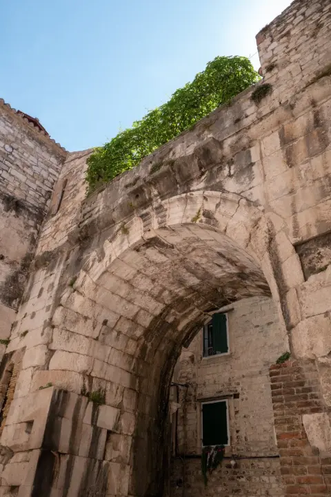 Arche de pierre envahie de lierre au-dessus d'une ruelle, Split