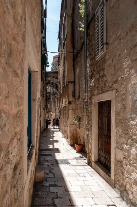 Impasse etroite bordee de pots de fleurs menant vers une placette, Split