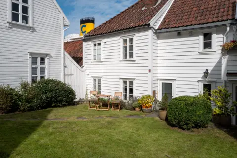 La cheminée d’un paquebot dépasse derrière les toits des maisons blanches, Stavanger