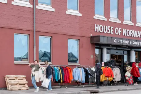 La façade rouge d’une boutique de souvenirs, portants et troll sur le trottoir, Stavanger