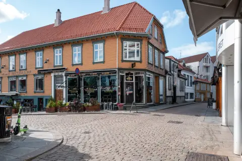 Une maison de bois orange au coin d’une rue pavée, Stavanger