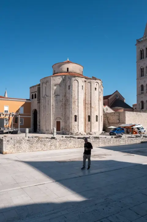 Un passant devant l'église romane ronde de Saint-Donat, Zadar