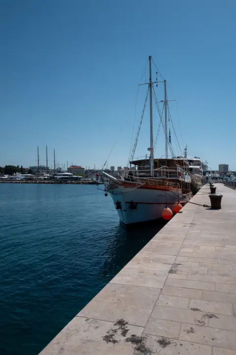 Voilier en bois amarré au quai, marina en arrière-plan, Zadar