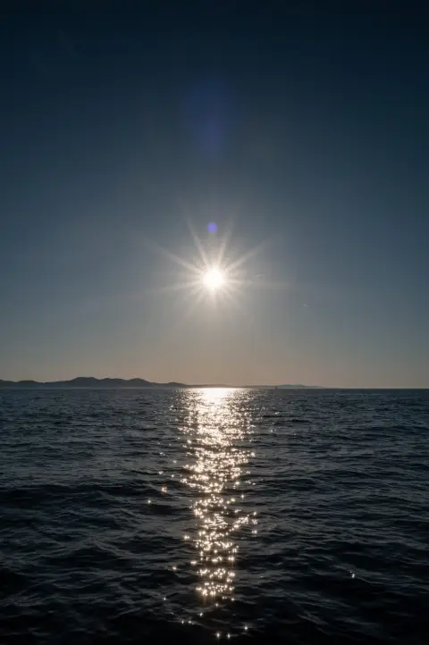 Étoile solaire perçant un ciel bleu profond au-dessus de la mer, Zadar