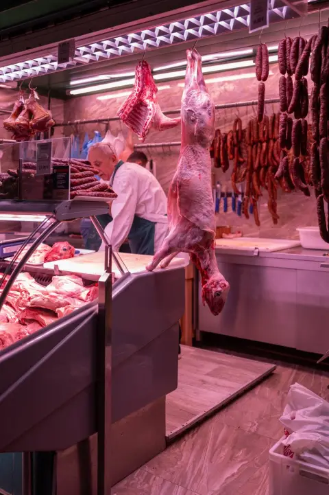 Carcasse suspendue entre les saucisses fumées d'une boucherie du marché, Zagreb