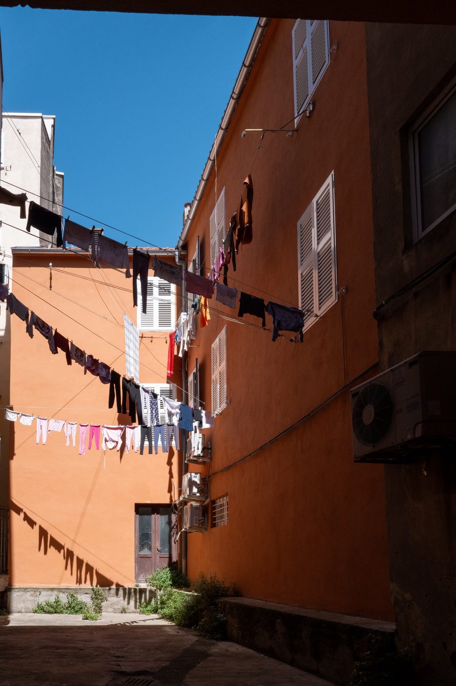 Clotheslines stretched star-like between orange façades, Zadar