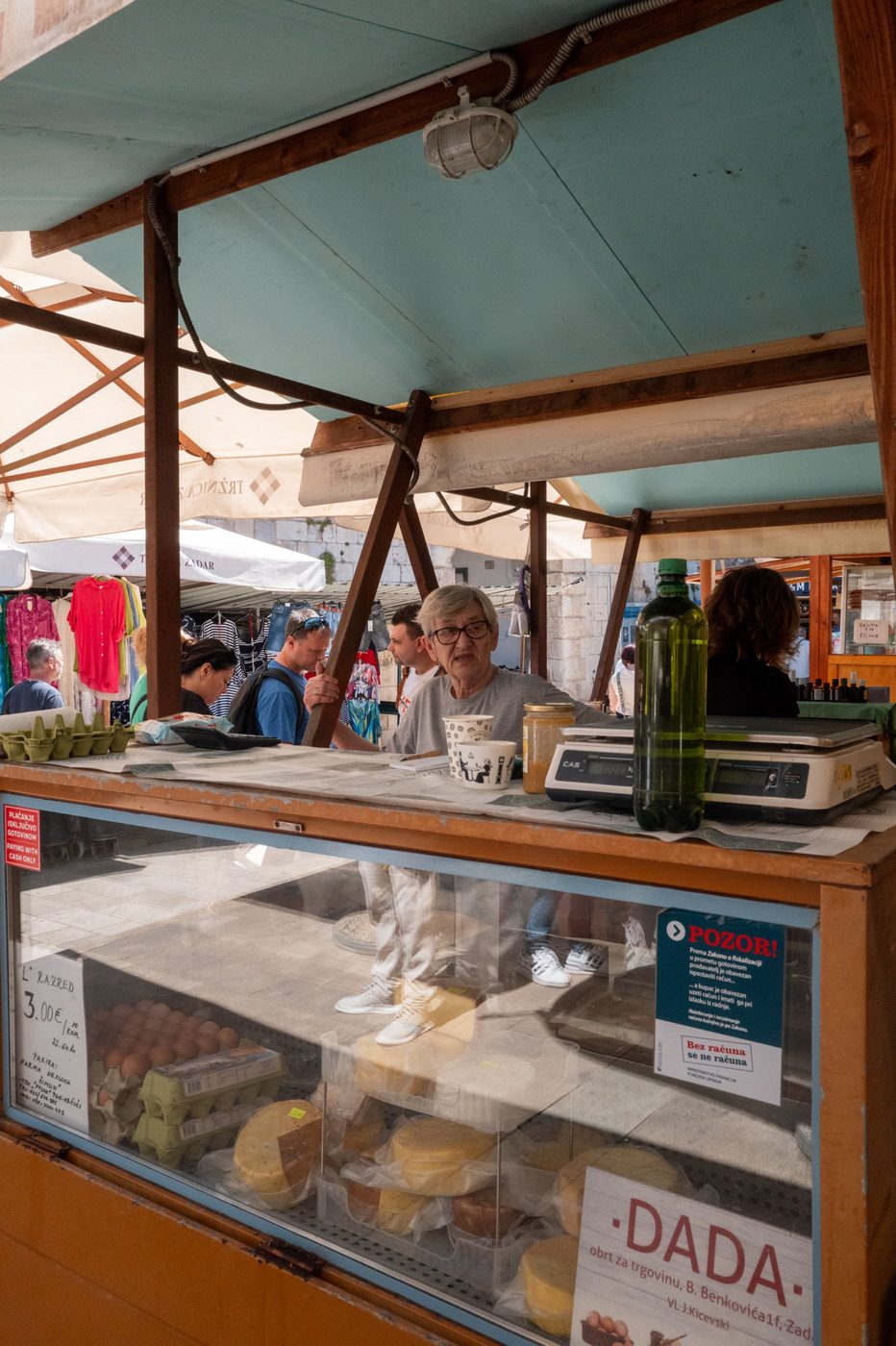 Cheese and egg vendor beneath the turquoise market awning, Zadar