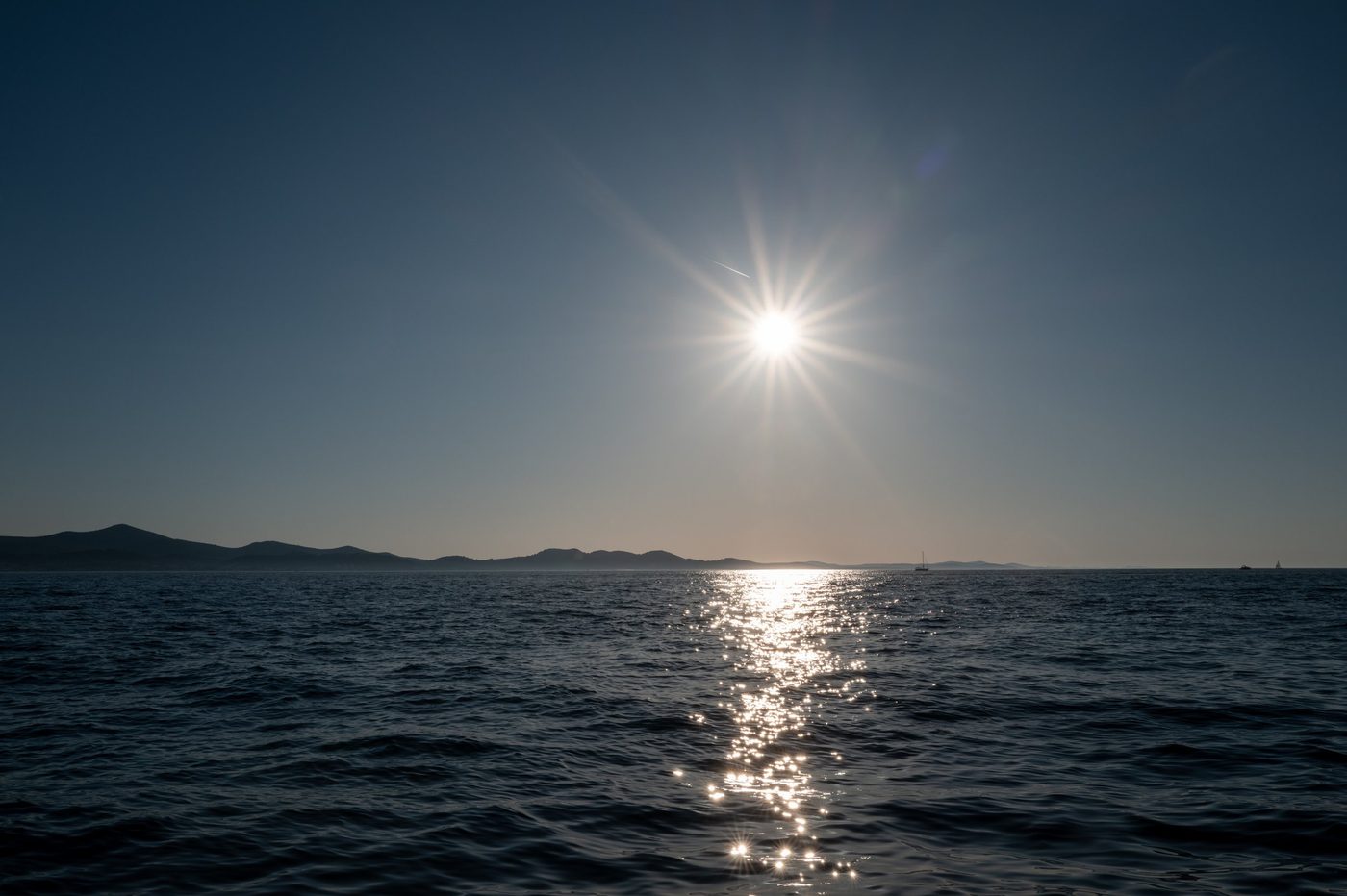 Sun bursting like a star above the calm sea, Zadar