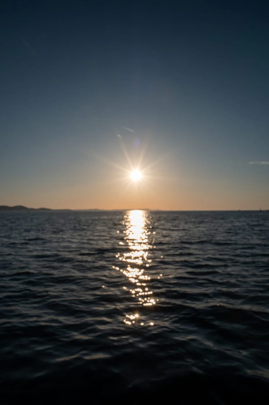 Coucher de soleil orangé se reflétant sur une mer sombre, Zadar