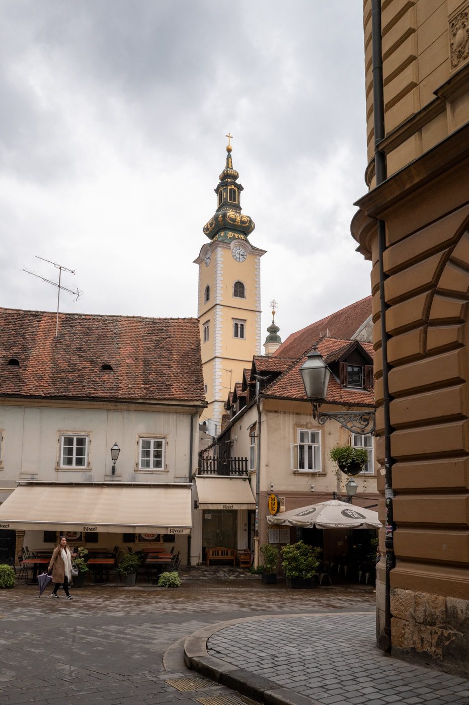 Baroque bell tower with a golden dome overlooking a cobbled square, Zagreb