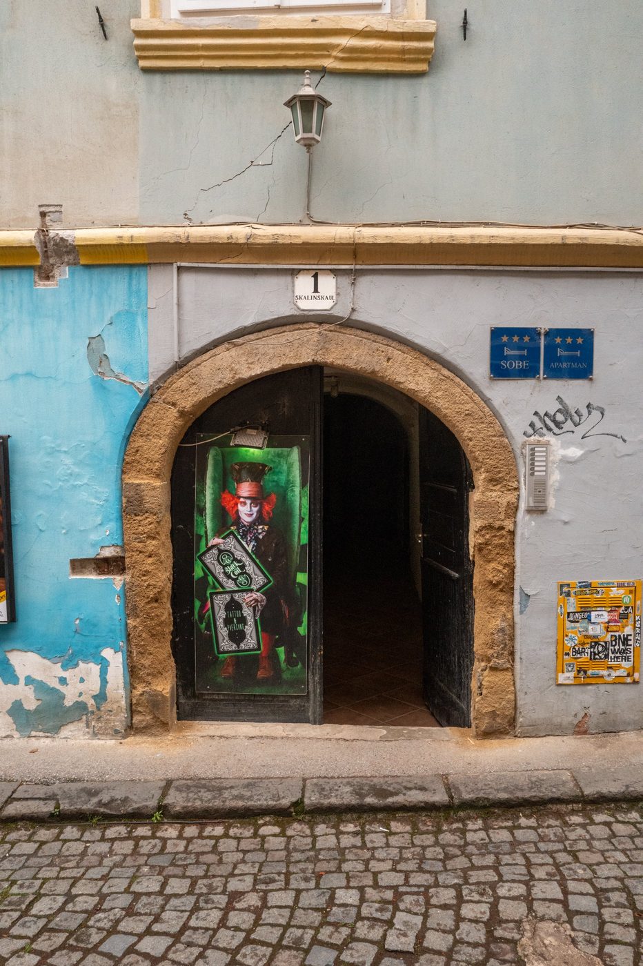 Vaulted gateway adorned with a poster for the Mad Hatter, Zagreb