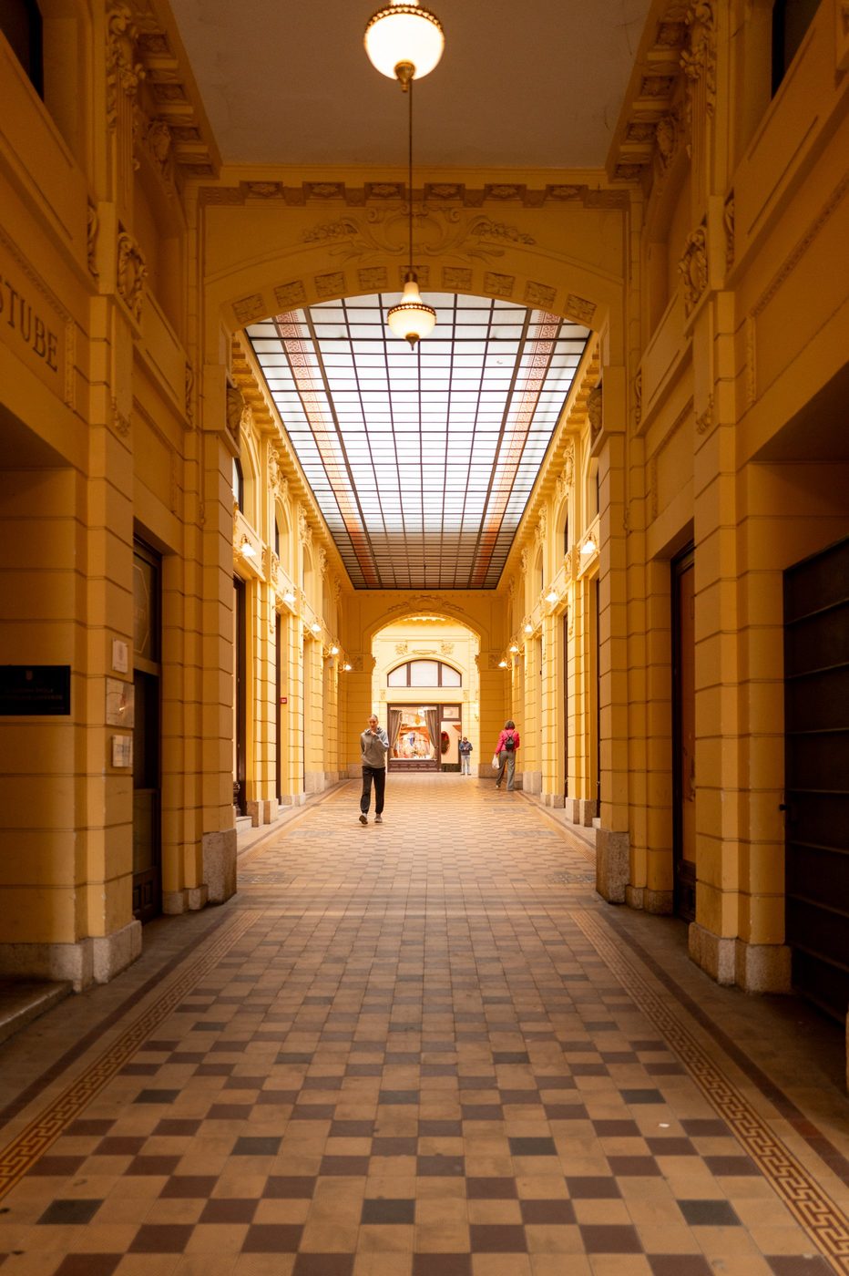 Yellow Art Nouveau passage with a gridded glass roof and checkered floor, Zagreb
