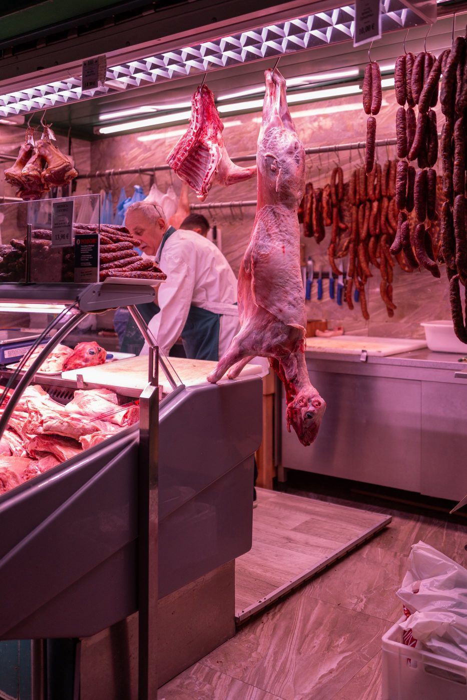 Carcass hanging among the smoked sausages of a market butcher shop, Zagreb