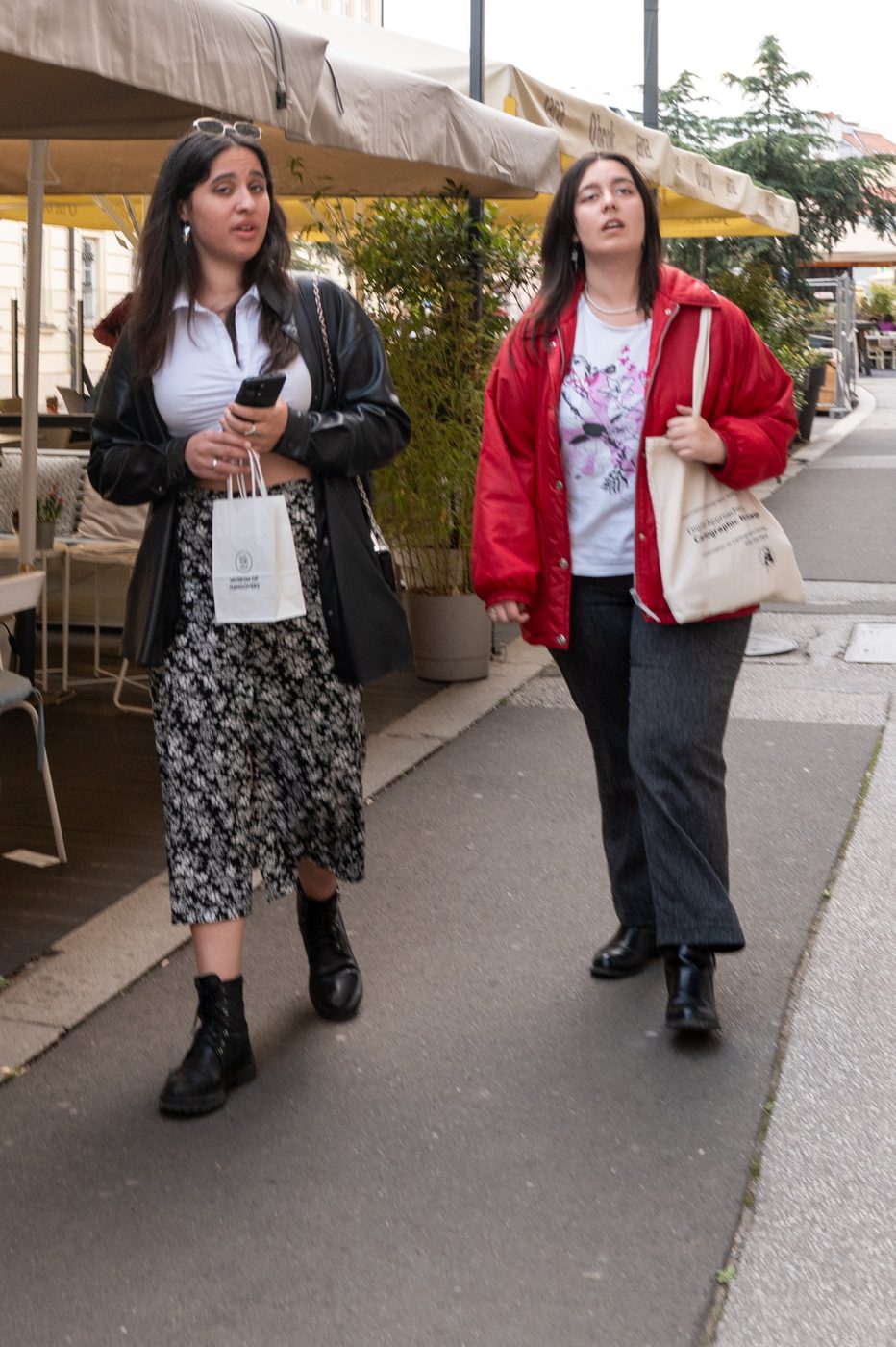 Two friends walking together, canvas bags in hand, Zagreb