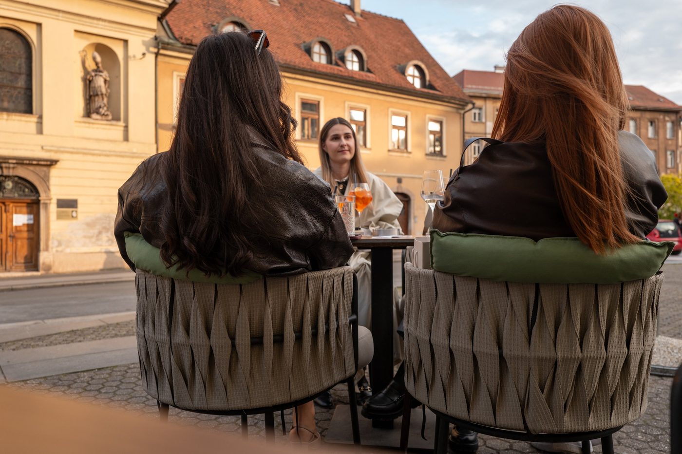 Three friends seated on a terrace in the golden evening light, Zagreb